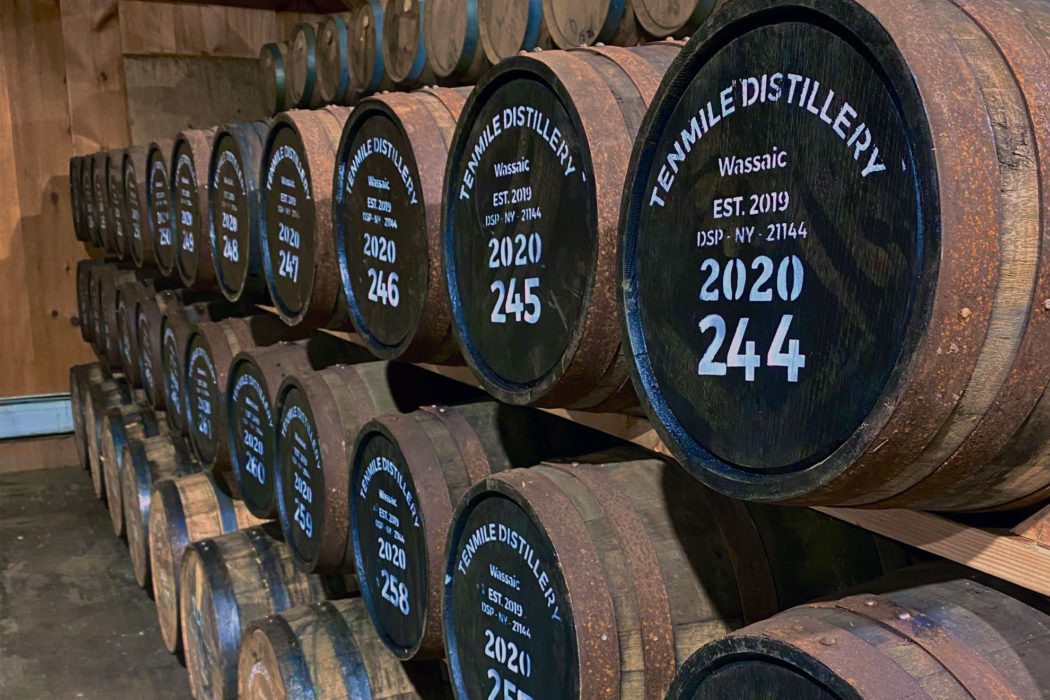 Tenmile Distillery Cask Warehouse Wooden barrels lined up on shelves in a warehouse.