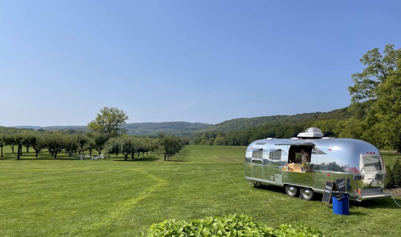 Airstream parked in an orchard