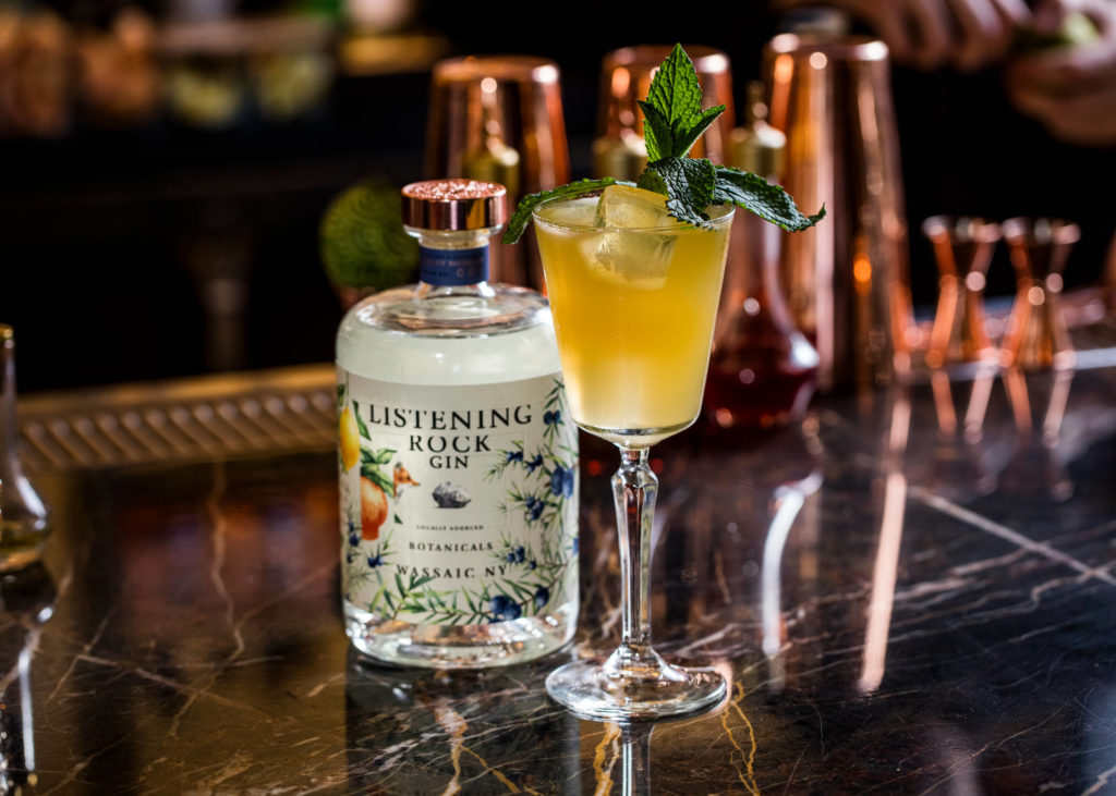 Cocktail with bottle of Listening Rock Gin on a bar